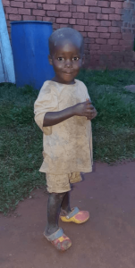 Image of a young boy named JOSHUA MUSASIZI smiling